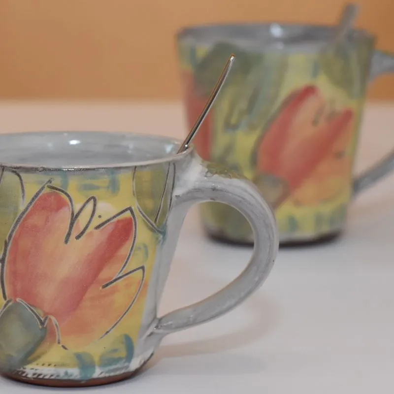 Keramiktassen & Becher - Handgemachte Keramiktasse in konischer Form mit getöpferter Tasse aus Keramik im Hintergrund.